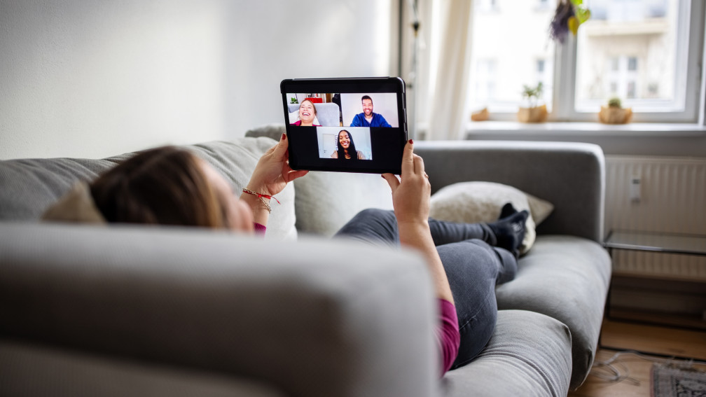 Person in einem Videocall auf dem Sofa