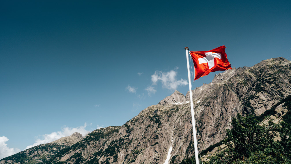 Schweizer Fahne mit Bergen im Hintergrund