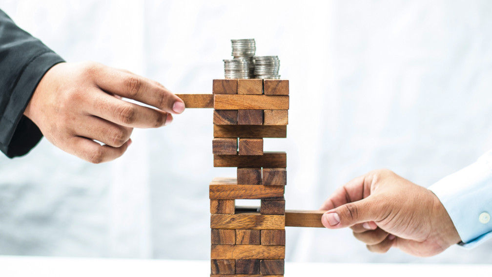 Geschicklichkeitsspiel Wackelturm mit Geld darauf  