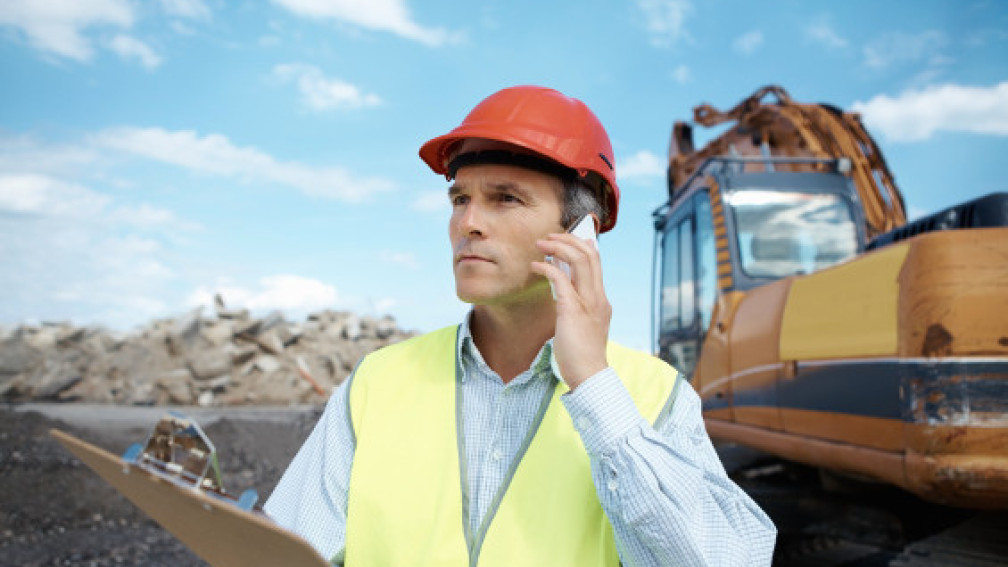 Arbeiter in gelber Weste telefoniert