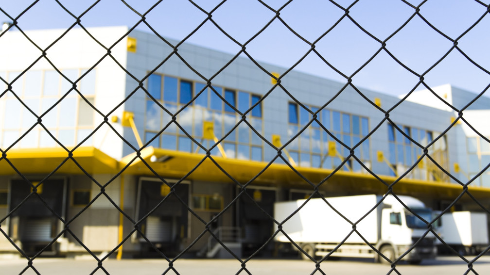Hag vor Logistikzentrum mit Lastwagen im Hintergrund