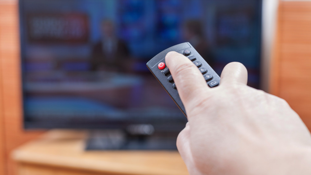 Hand schaltet mit Fernbedienung Fernseher ein