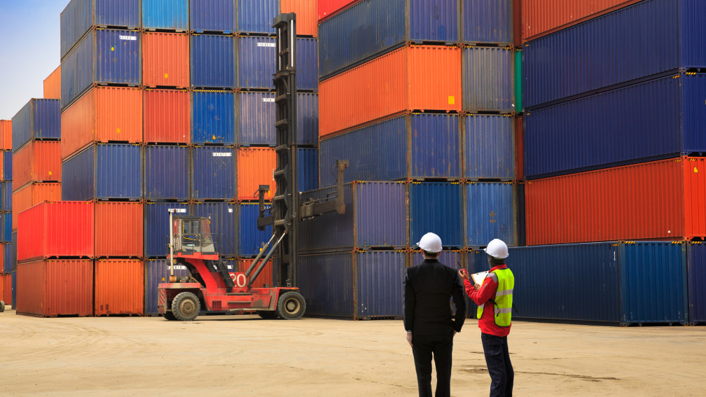 Containerstapel zwei Männer die darauf zughen 