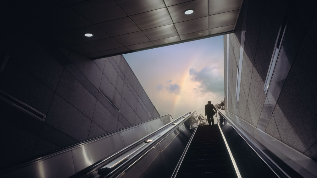 Frau fährt mit Roltreppe