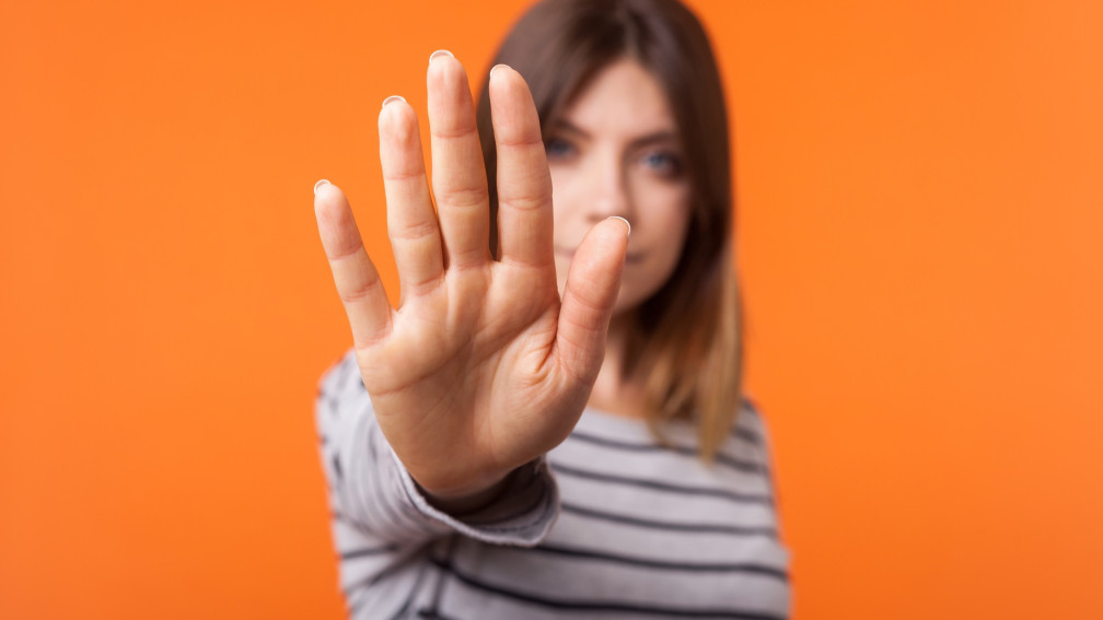 Woman holds out hand, signalling "stop"