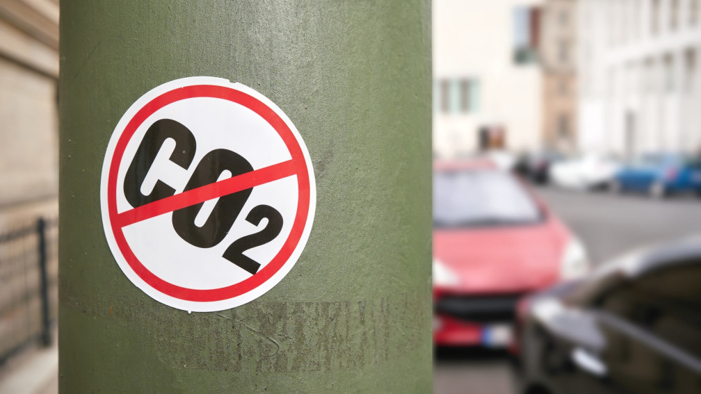 Kleber mit "CO2" das durchgestrichen wurde klebt am Pfosten einer Strassenlampe