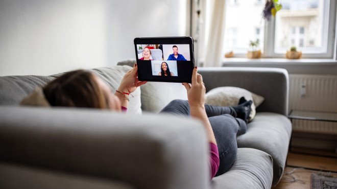 Person in einem Videocall auf dem Sofa