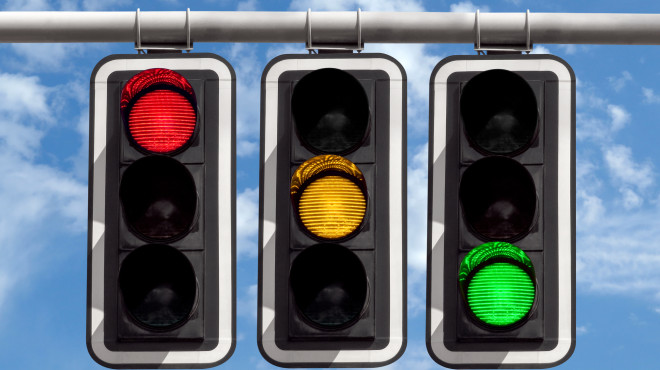 Drei hängende Ampeln eine rot, eine orange, eine grün