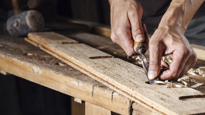 Hände, die Nägel auf dem Holzbrett sortieren