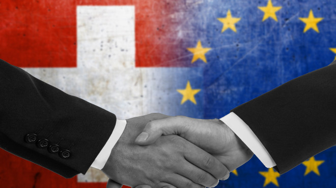 Händeschütteln vor EU und Schweiz Flaggen