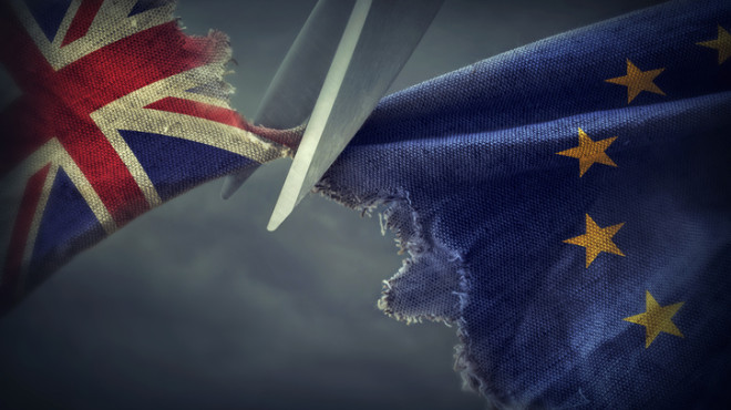 Eine Schere schneidet die EU-Flagge und die Flagge von Grossbritannien auseinander.