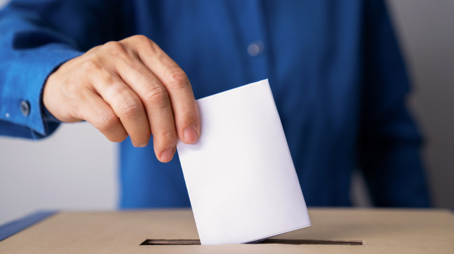 Mann wirft Wahlzettel in Urne