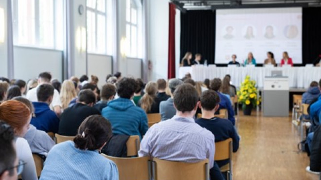 Gymnasiastinnen und Gymnasiasten hören einem Vortrag zu 