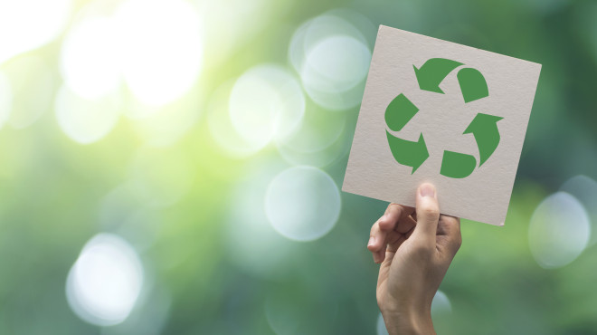 Hand streckt Recyclingschild in die Luft