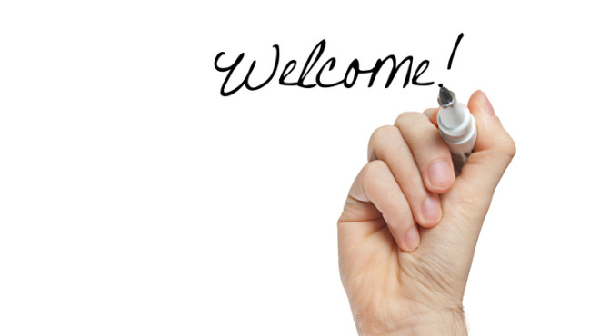 Une main écrit "welcome!"