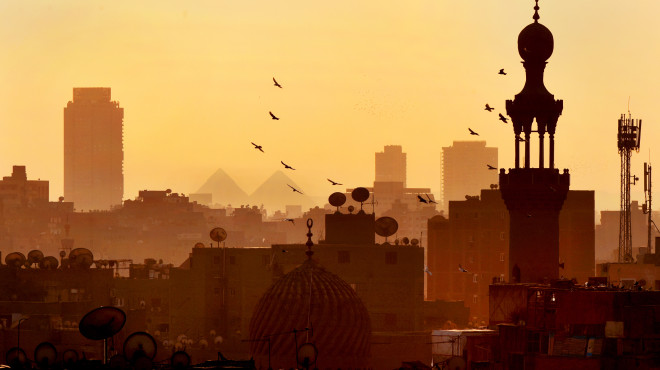 Die Skyline Kairos im Sonnenuntergang - Vögel fliegen am Himmel