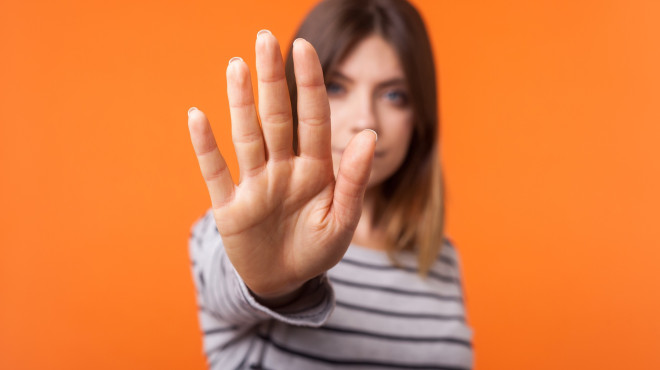 Woman holds out hand, signalling "stop"