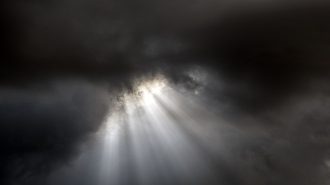 Dunkle Wolken durch die ein paar Lichtstrahlen brechen