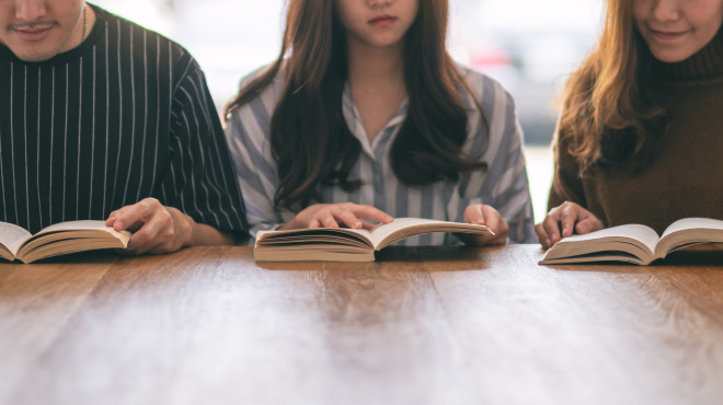 Drei Jugendliche lesen am Tisch
