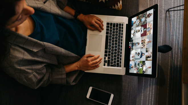 Frau sitzt vor Computer im Onlinemeeting