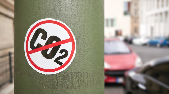 Kleber mit "CO2" das durchgestrichen wurde klebt am Pfosten einer Strassenlampe