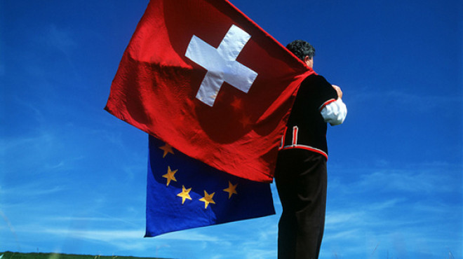 Mann schwingt EU und Schweizer Fahne