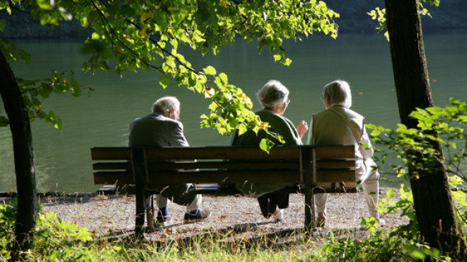 Drei Personen sitzen auf einer Bank