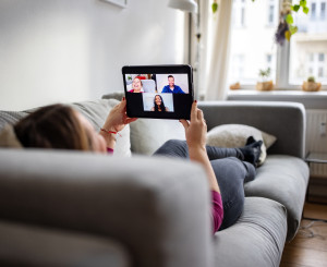 Person in einem Videocall auf dem Sofa