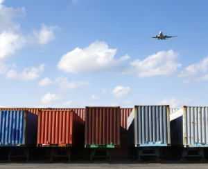 Molteplici container per spedizioni e un aereo in volo
