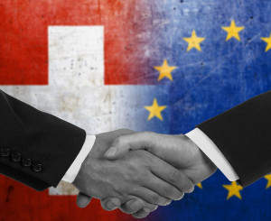 Händedruck mit Schweizer- und EU-Fahne