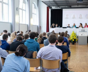 Gymnasiastinnen und Gymnasiasten hören einem Vortrag zu 