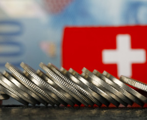 Münzen, hunderter Note und Schweizer Fahne