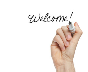 Une main écrit "welcome!"