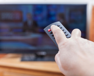 Hand schaltet mit Fernbedienung Fernseher ein