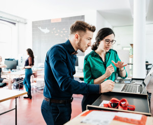 Junge Angestellte arbeiten in modernem Büro zusammen