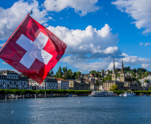 Symbolbild: (Schweizer Flagge im Vordergrund, Stadt Luzern im Hintergrund)