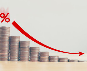 Münzstapel mit Grafik die ein sinken verdeutlicht