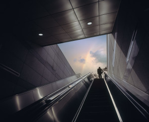 Frau fährt mit Roltreppe