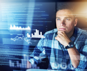 Mann sitzt hinter durchsichtigem Bildschirm mit digitalen Informationen