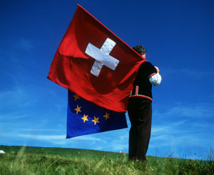 Mann schwingt Schweizer und EU-Fahne